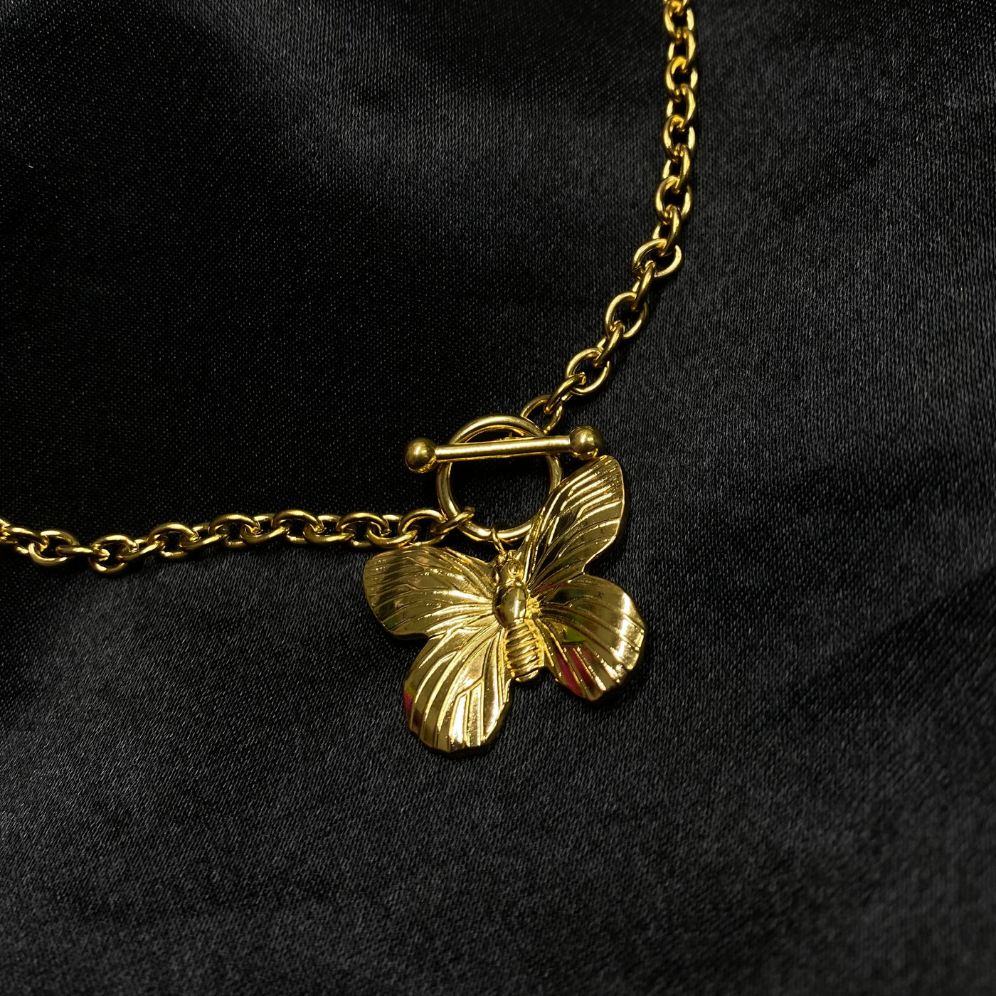 Collar Cloe con dije de mariposa con cadena de eslabones circulares y broche T de acero inoxidable con baño de oro de 18 K