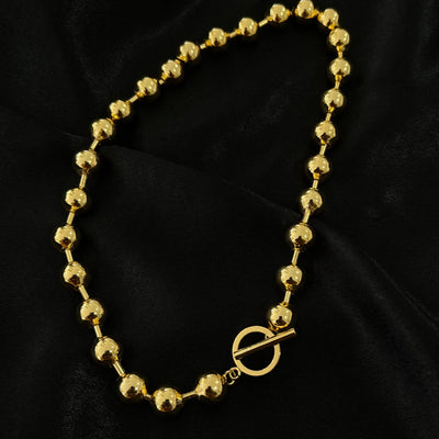 Collar Greta de bolitas Chunky con broche T en oro laminado.