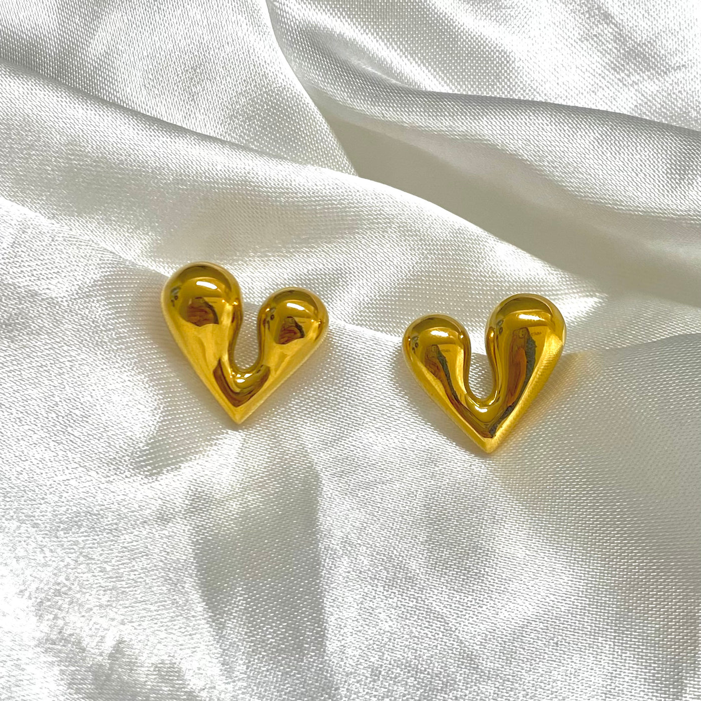 Aretes Lia con forma de corazon mediano de acero inoxidable con baño de oro 18K.