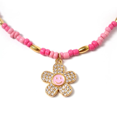 Collar Jazmin color rosa con dije de flor con cara feliz en oro laminado de 18K y zirconias - AMATINA Joyería
